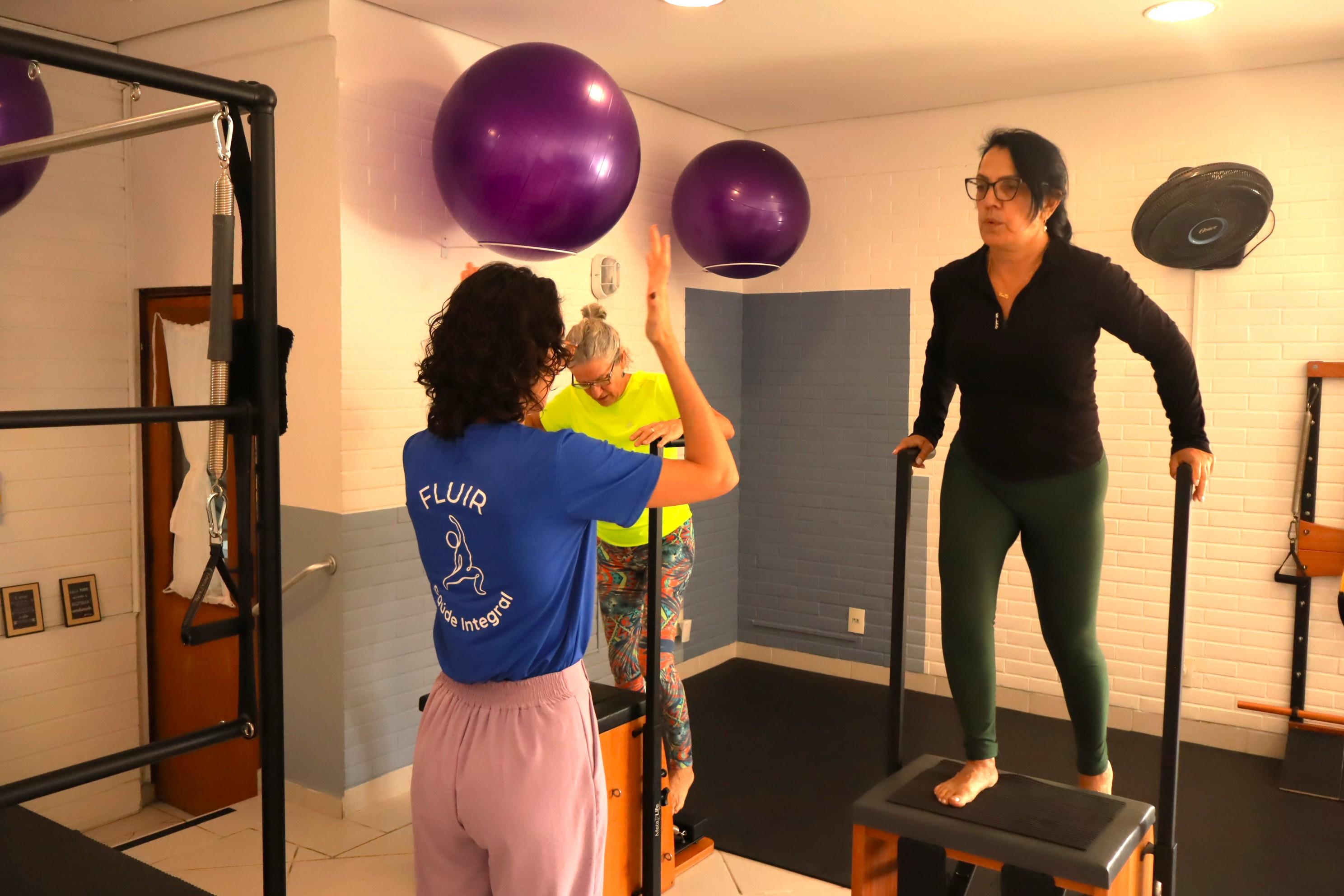 Fisioterapeuta orientando alunas durante aula de Pilates no Fluir